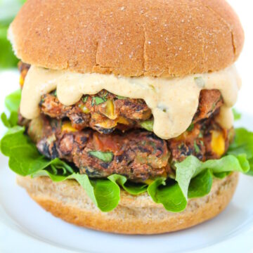 Vegan southwest black bean burger with creamy sauce on a white plate