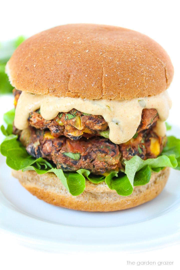 Vegan southwest black bean burger with creamy sauce on a white plate