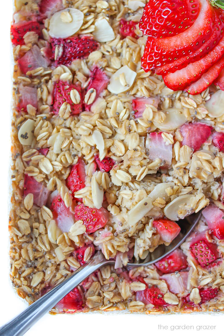 Close up view of oatmeal in a glass baking dish with serving spoon