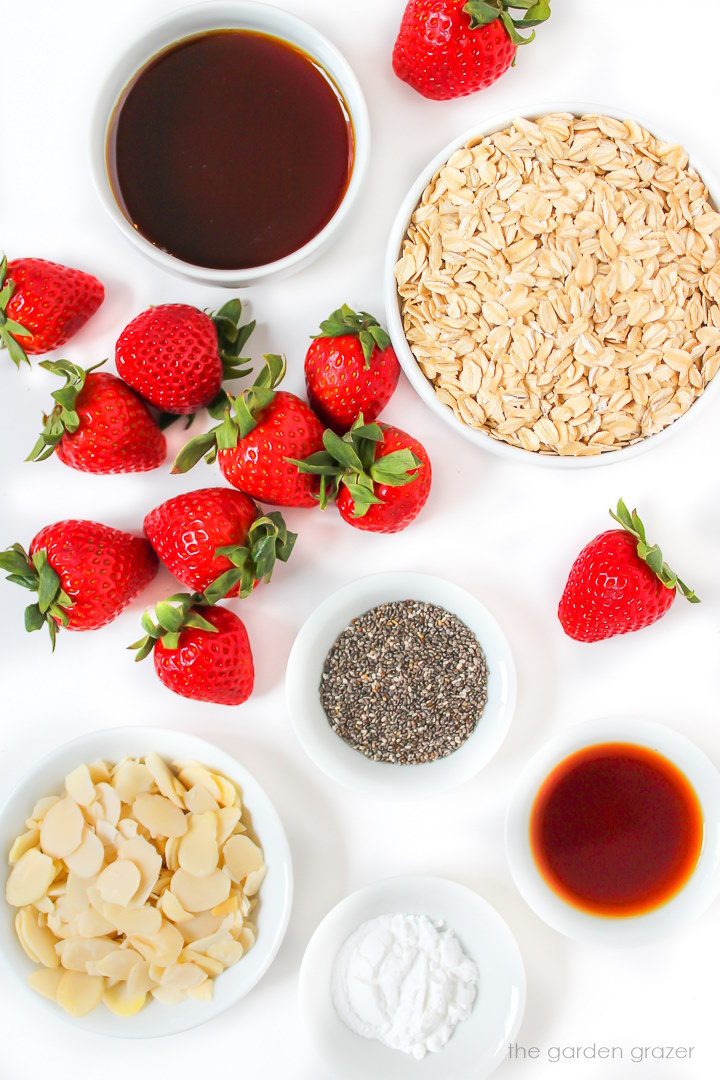 Raw ingredients laid out on a white table for strawberry baked oatmeal