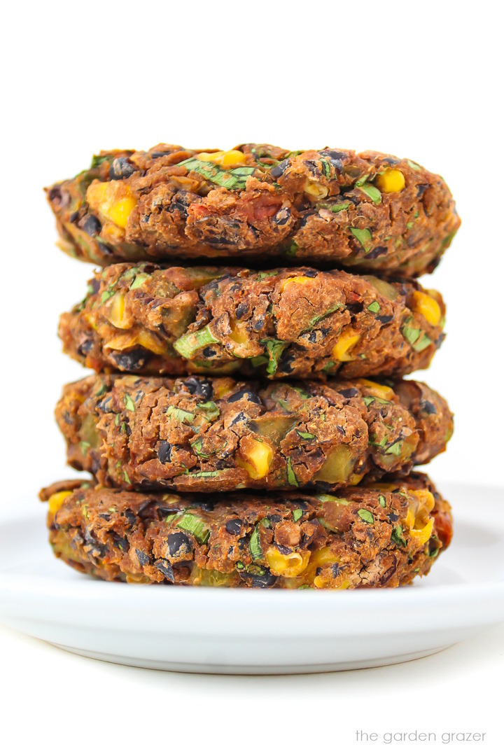 Four southwest black bean burger patties stacked on a white plate