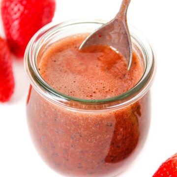 Strawberry balsamic dressing in a glass jar with serving spoon