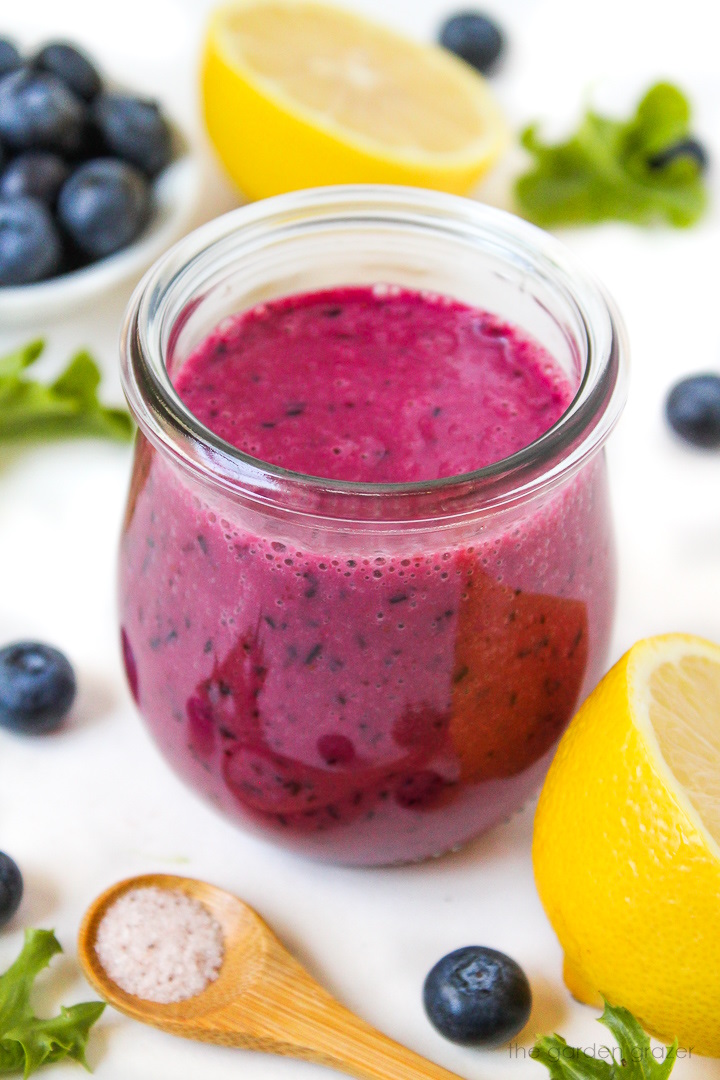 Blueberry salad dressing in a small glass jar on a white table