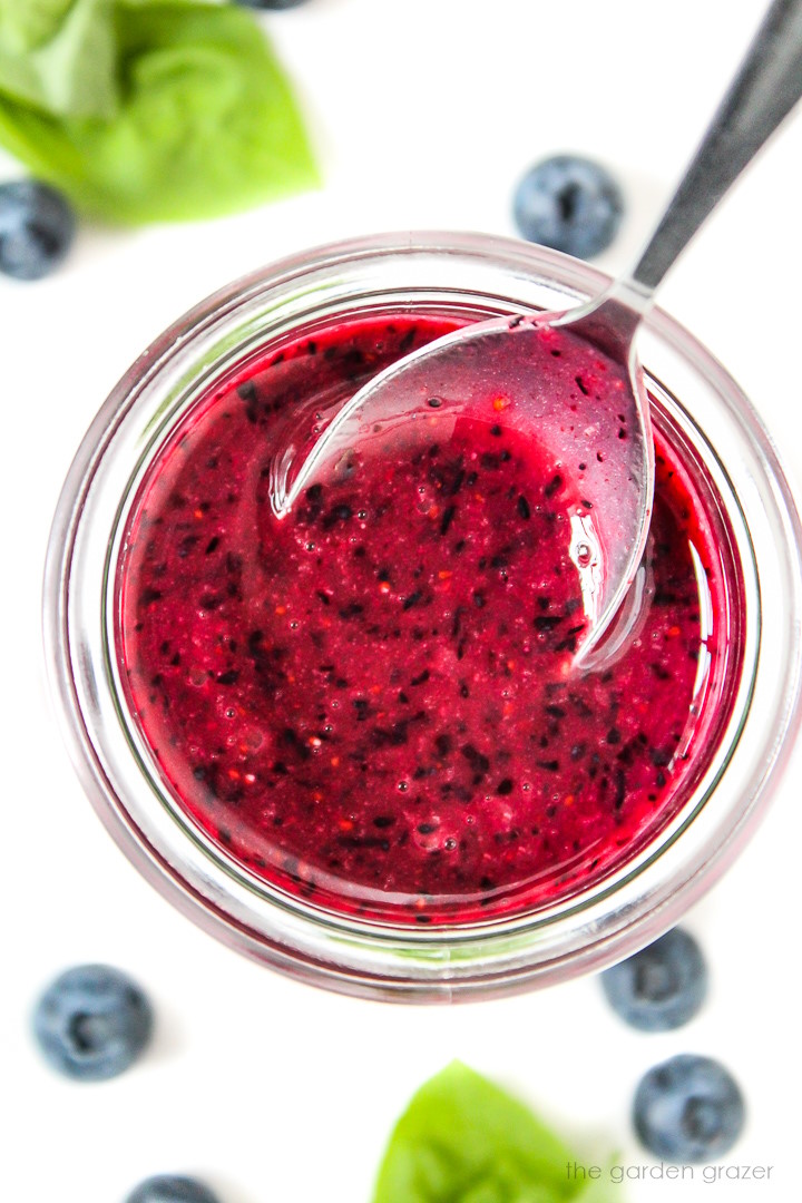 Oil-free blueberry basil dressing in a glass jar with spoon