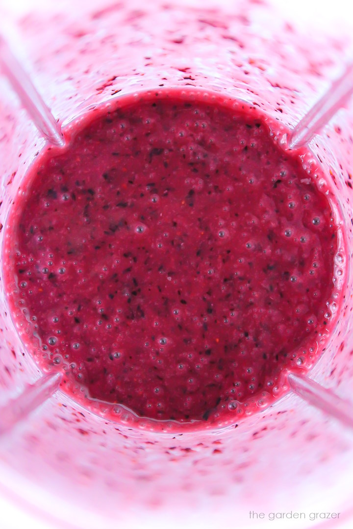 Overhead view of blended blueberry dressing in a small blender