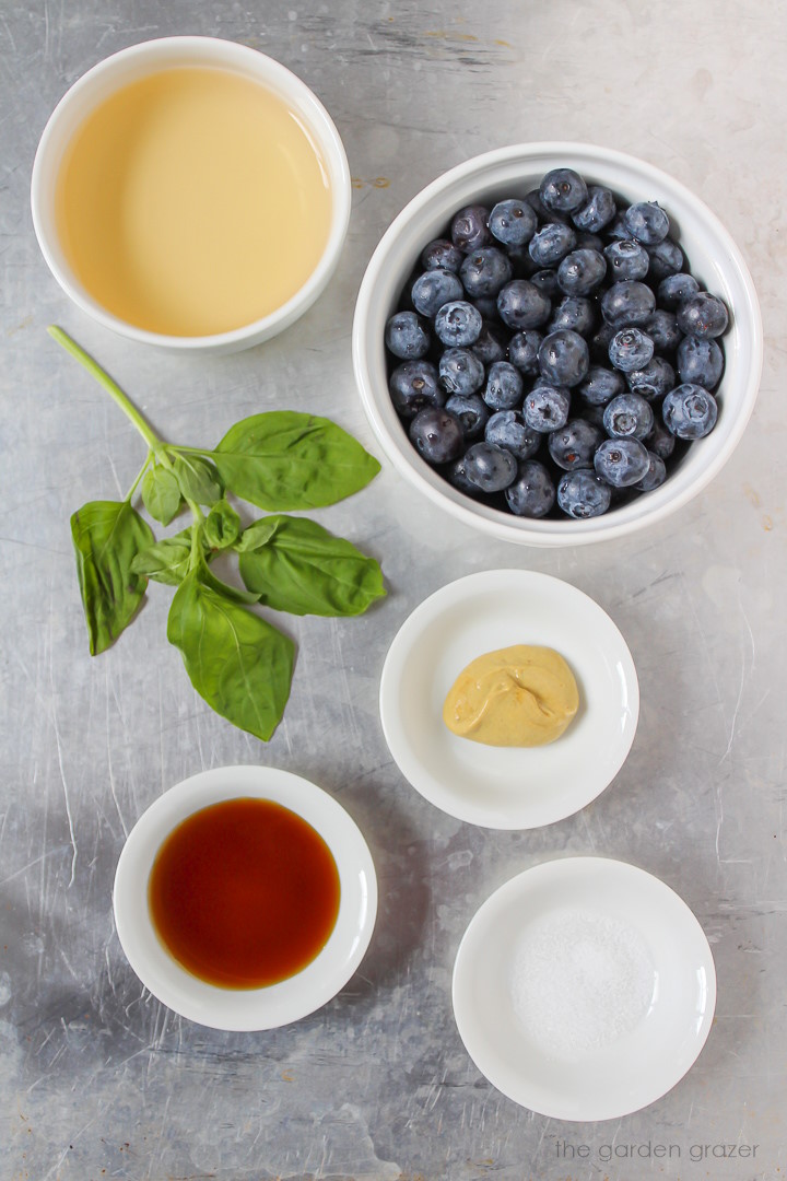 Fresh berries, basil, vinegar, mustard, and syrup laid out in separate bowls