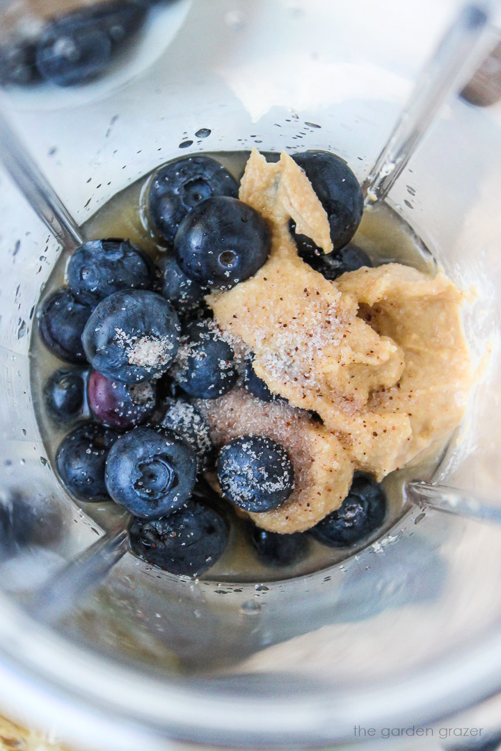 Overhead view of preparing ingredients in a small blender before blending