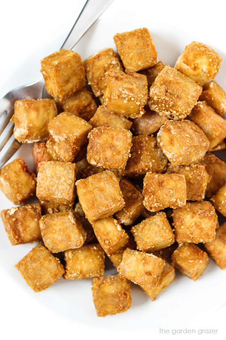 Overhead view of a plate of oil-free crispy baked tofu with fork