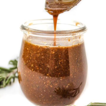 Maple balsamic dressing in a small glass jar with spoon