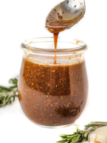Maple balsamic dressing in a small glass jar with spoon
