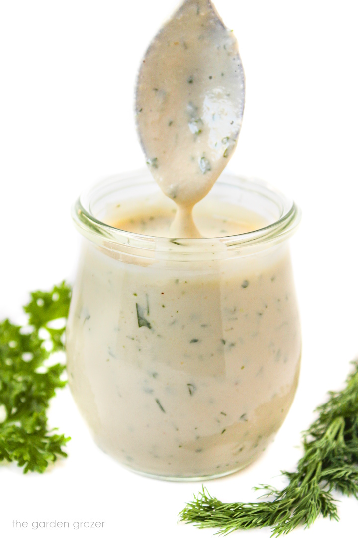 Oil-free vegan ranch dressing in a small glass jar with serving spoon