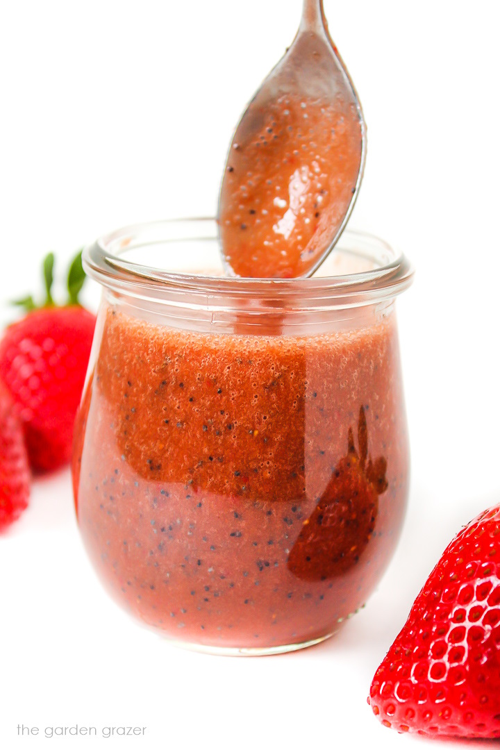 Oil-free strawberry balsamic dressing in a small glass jar with spoon