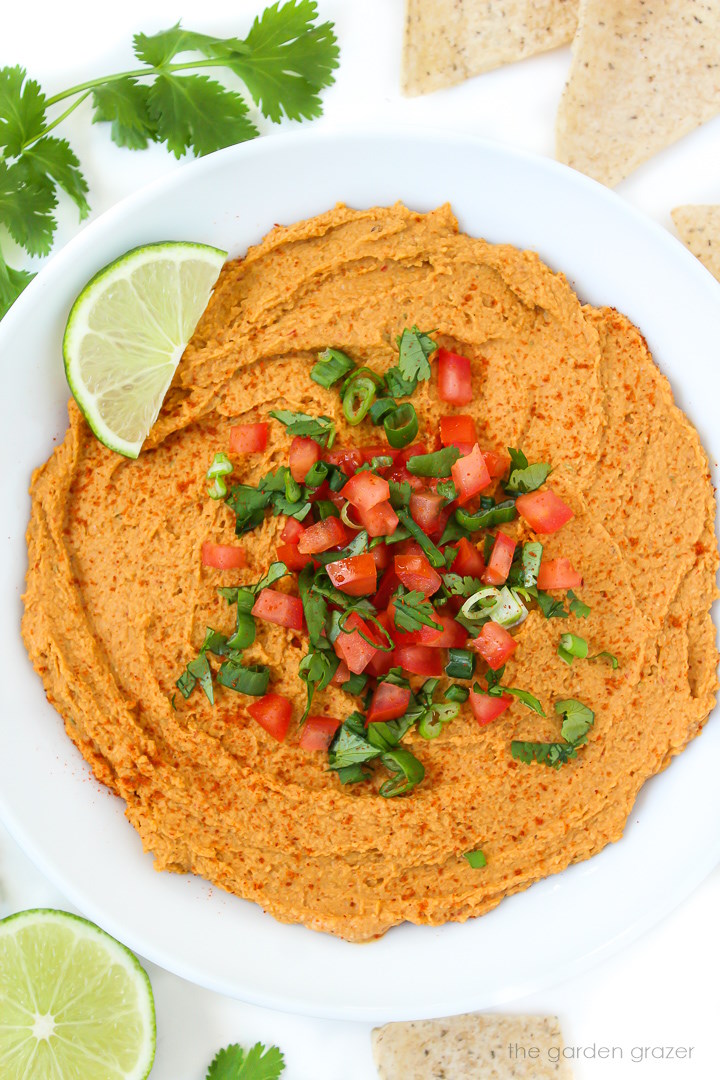 Chipotle taco hummus in a white bowl topped with tomato and cilantro