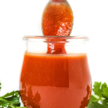 Oil-free vegan French Dressing in a small glass jar with serving spoon