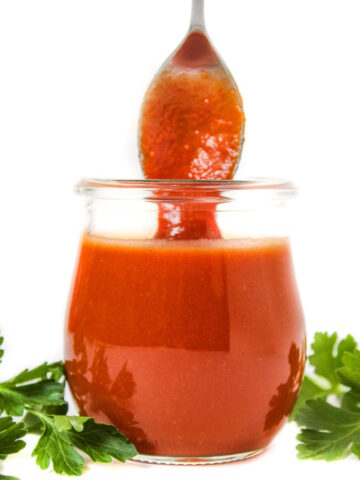 Oil-free vegan French Dressing in a small glass jar with serving spoon