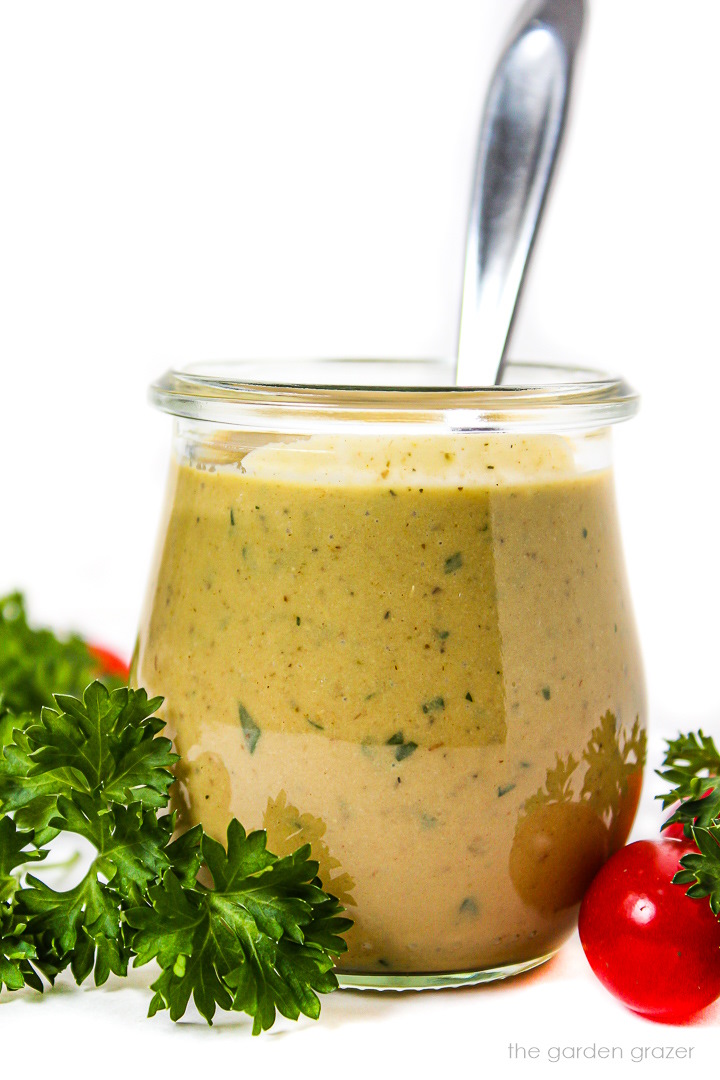 Vegan Italian Dressing in a small glass jar with fresh parsley on the side