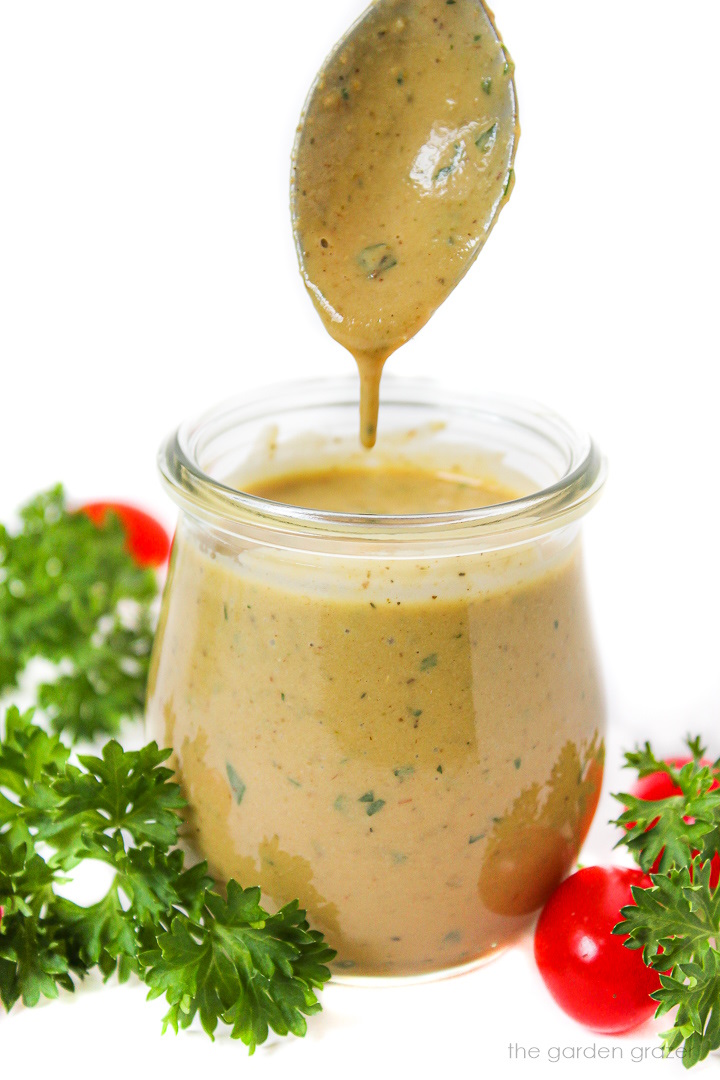 Oil-free vegan Italian salad dressing in a glass jar with serving spoon
