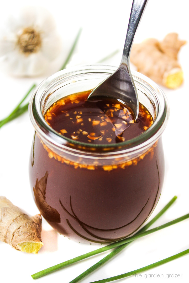 Vegan stir fry sauce in a small glass jar with spoon