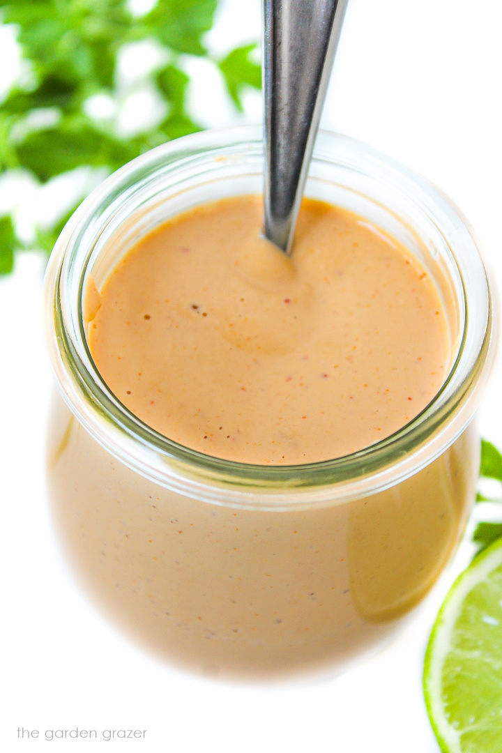 Chipotle crema in a small glass jar with serving spoon