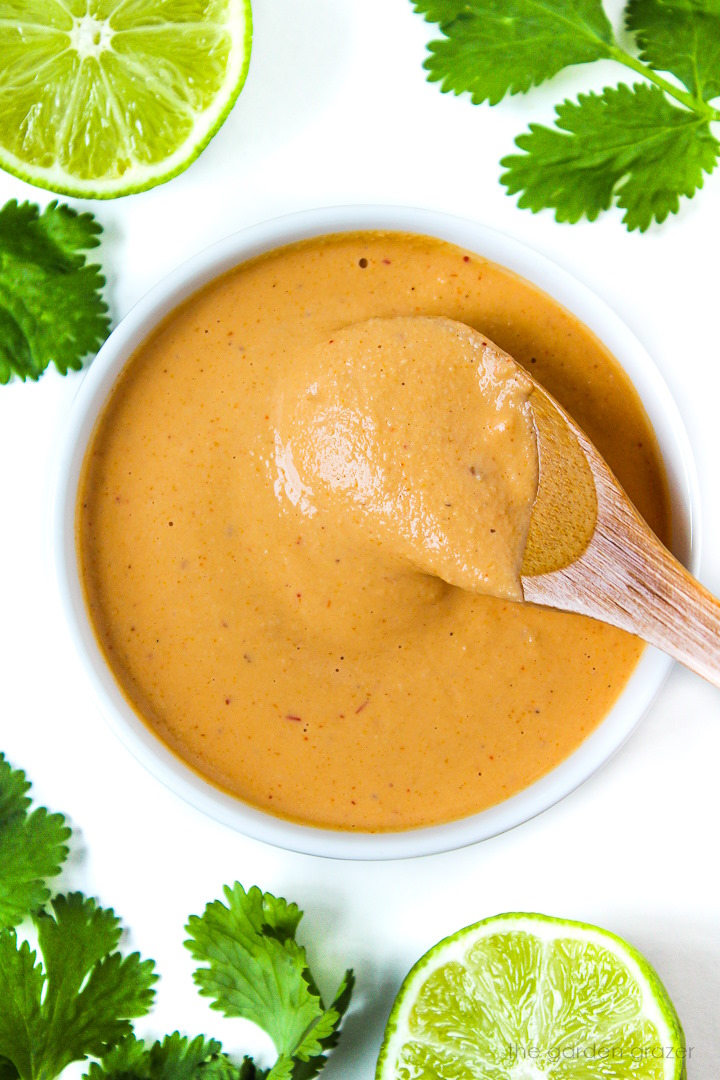 Overhead view of chipotle crema in a small white bowl with serving spoon