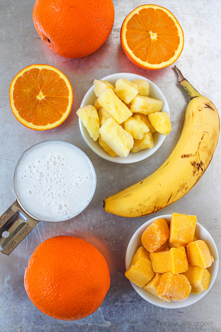 Dairy-free milk and fresh fruit ingredients laid out on a metal tray