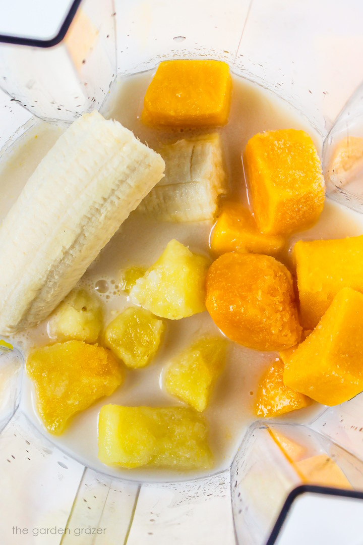 Overhead view of smoothie ingredients in a blender before blending