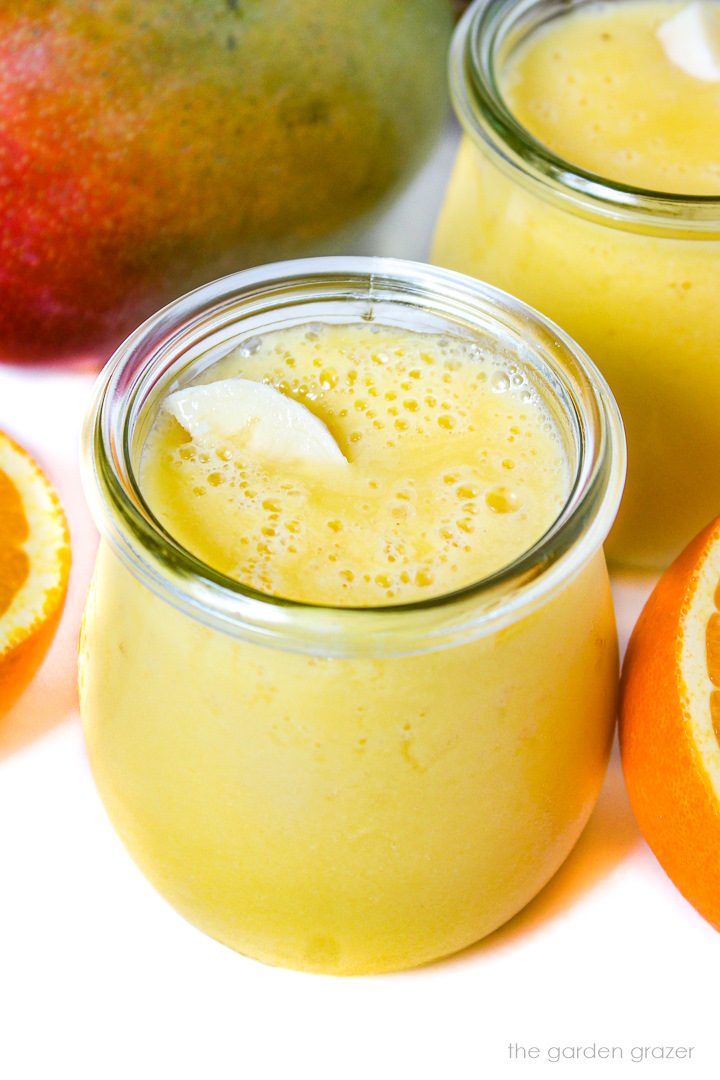 Close up view of mango pineapple smoothie in a small glass jar
