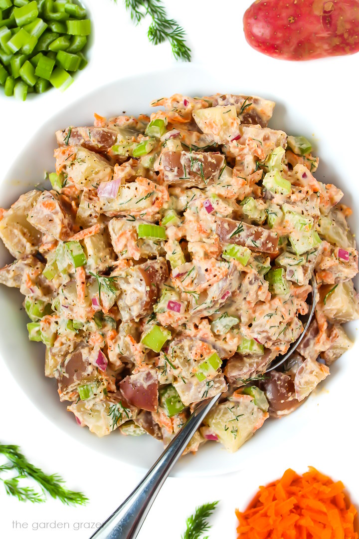 Overhead view of vegan potato salad in a white bowl