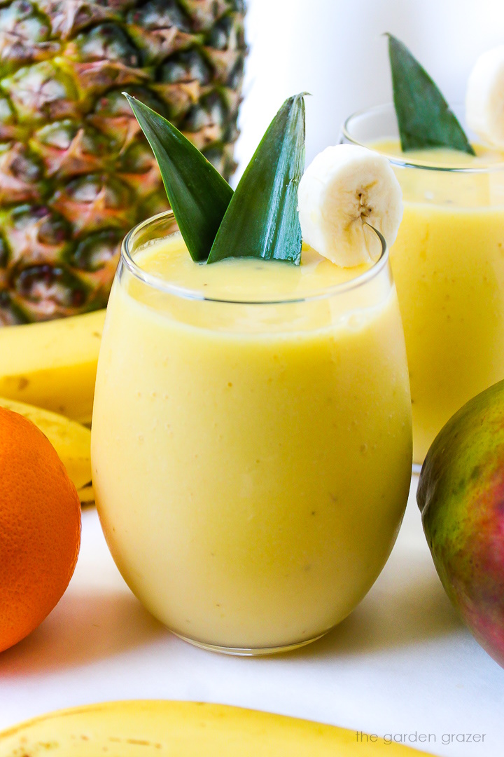 Close up view of vegan mango pineapple smoothie in a glass