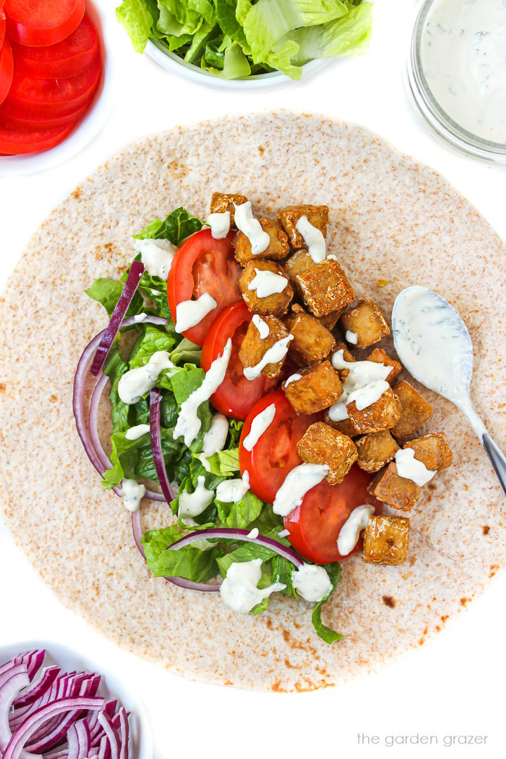 Open-faced crispy tofu wrap topped with ranch dressing