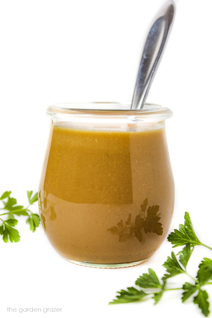 Side view of maple Dijon dressing in a small glass jar