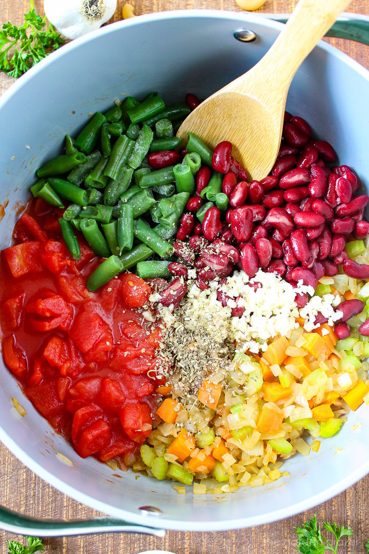 Overhead view of preparing soup ingredients in a large pot before mixing together