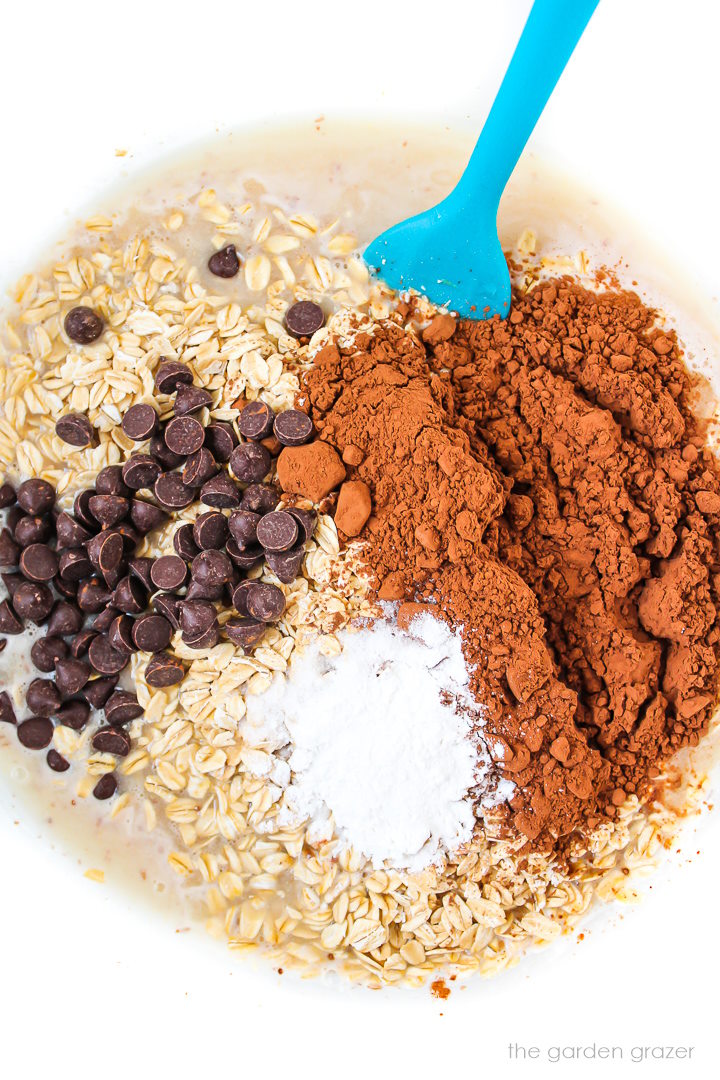 Ingredients for brownie baked oatmeal in a large bowl before mixing together