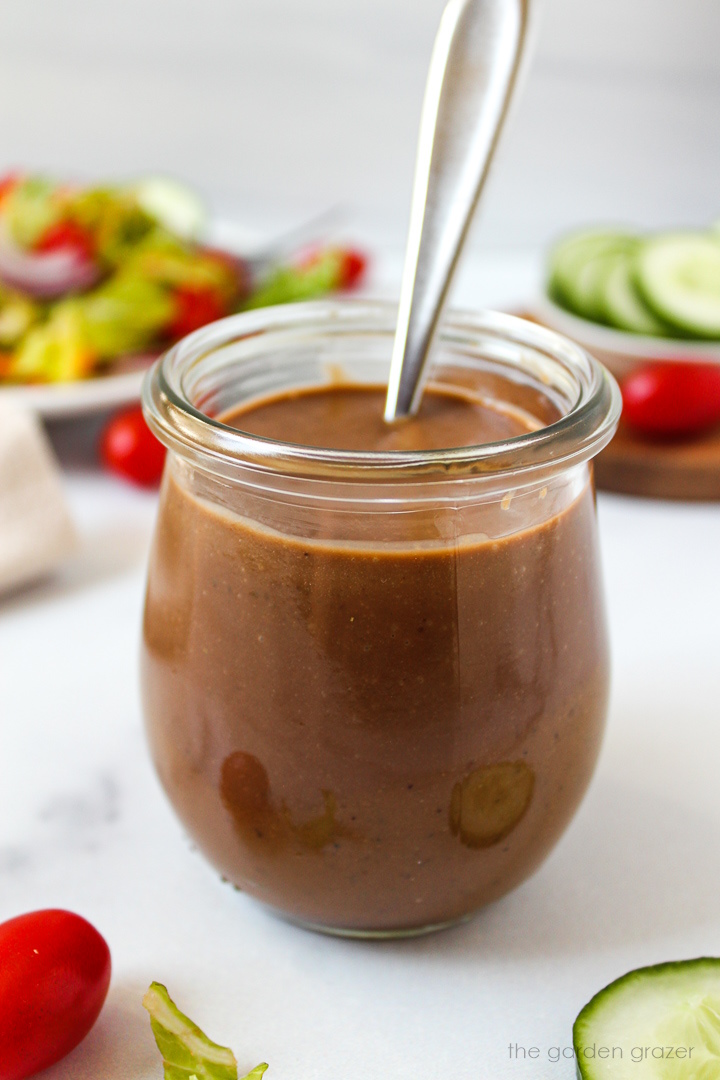 Oil-free creamy balsamic dressing in a small glass jar with serving spoon