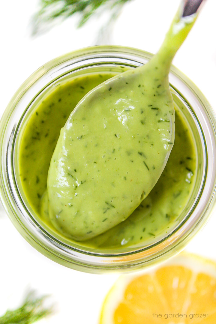 Close up view of creamy avocado dill dressing on a spoon