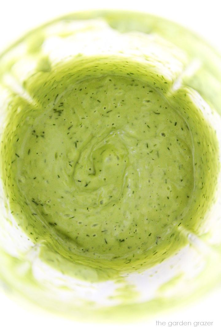Overhead view of dill dressing in blender cup after blending