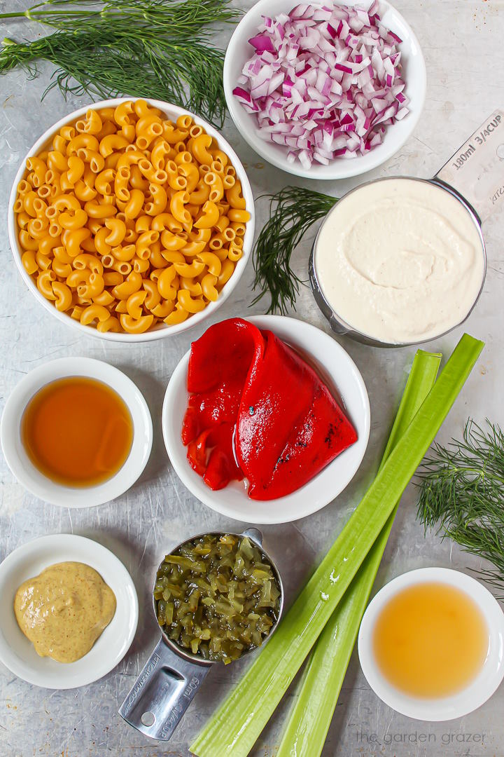 Onion, mustard, celery, dill, noodles, and relish ingredients laid out on a metal tray