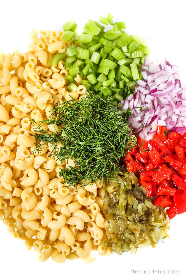 Ingredients for no mayo vegan macaroni salad in a large glass bowl before mixing together