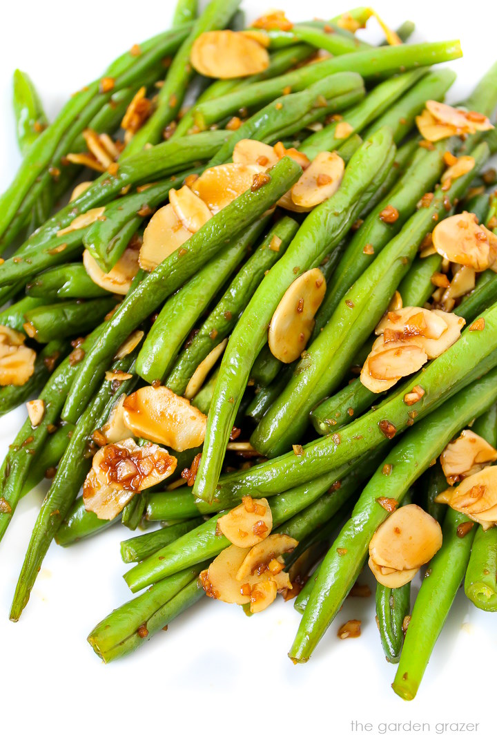 Almond garlic green beans with tamari glaze on a white plate