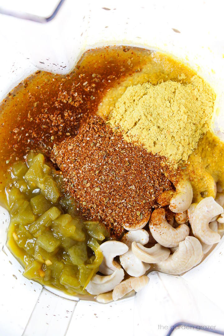 Overhead view of ingredients for Mexican-style cheese sauce in a blender before blending