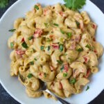 Overhead view of vegan Mexican mac and cheese in a white serving bowl with fork