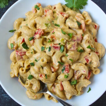 Overhead view of vegan Mexican mac and cheese in a white serving bowl with fork