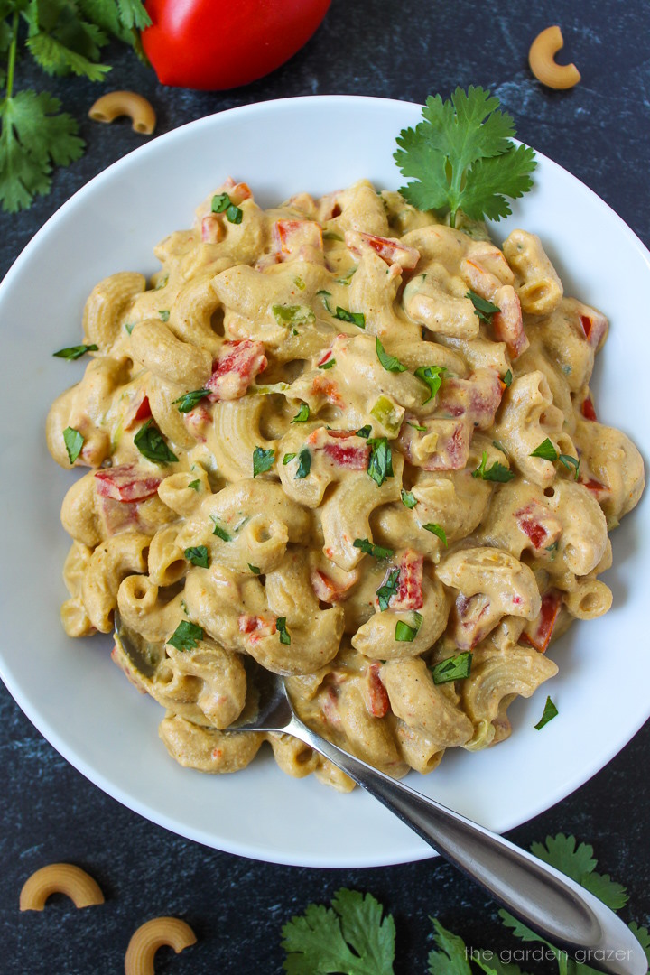 Overhead view of vegan Mexican mac and cheese in a white serving bowl with fork