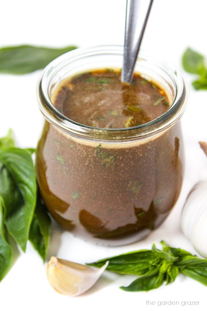 Blended balsamic dressing with fresh basil and garlic in a small glass jar