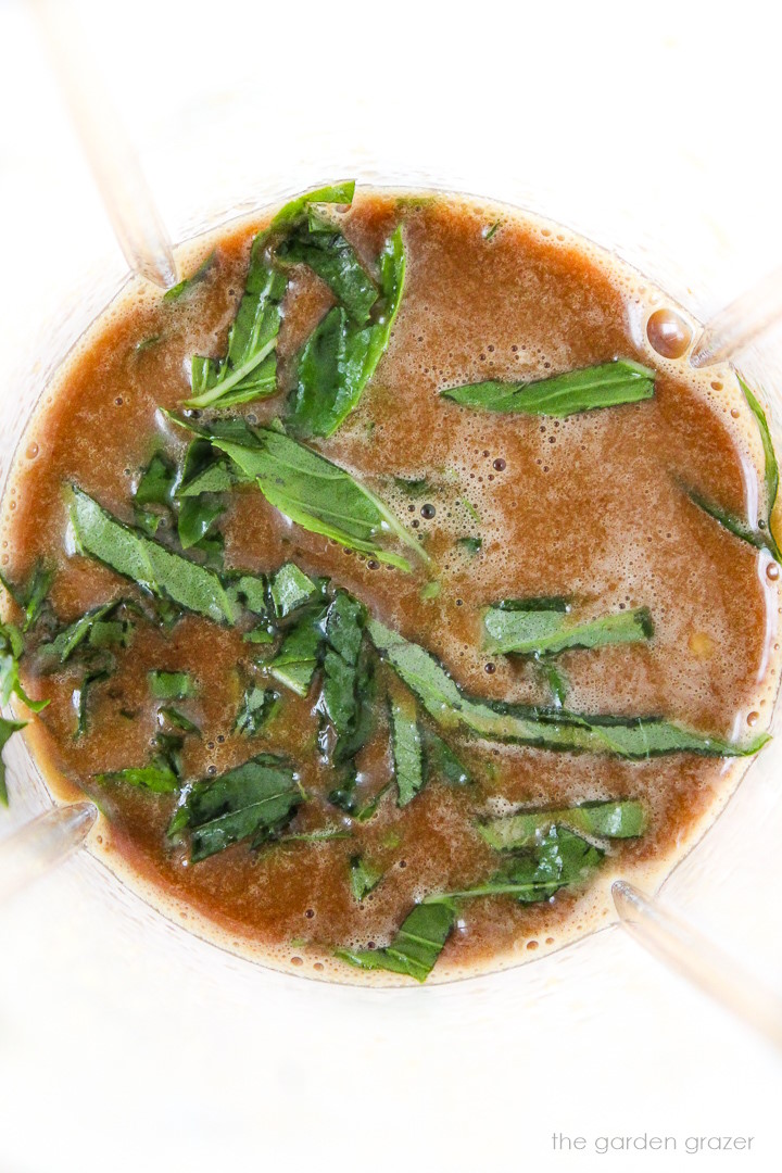 Overhead view of basil balsamic dressing in a blender cup before blending