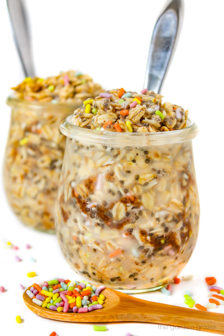 Two small glass jars of birthday cake overnight oats with colored sprinkles