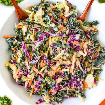 Overhead view of vegan kale and cabbage slaw in a white bowl
