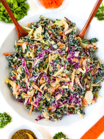 Overhead view of vegan kale and cabbage slaw in a white bowl