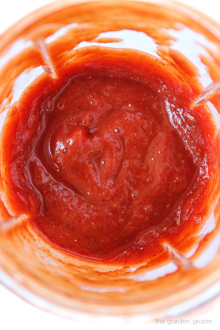 Overhead view of pizza sauce in a blender cup after blending