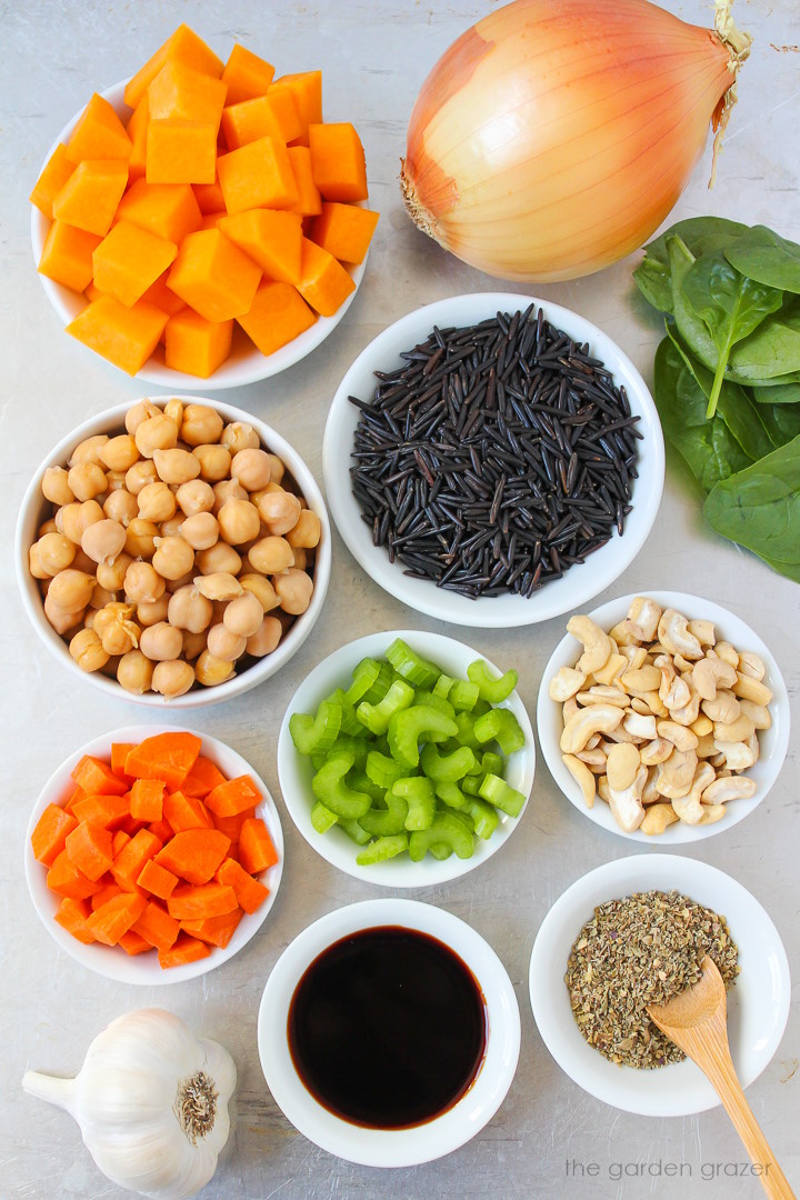 Diced squash, onion, garlic, chickpeas, spinach, carrot, celery, and seasoning ingredients laid out on a metal tray